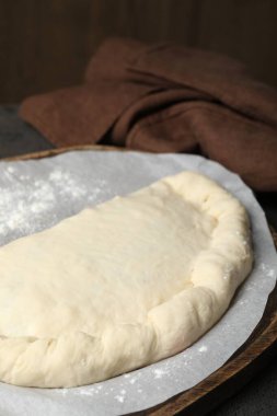 Tahtada pişmemiş calzone pizza, yakın plan.