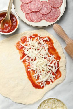 Calzone pizzası yapıyorum. Soslu, peynirli ve diğer malzemeli hamur.