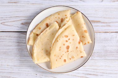 Ahşap masa üzerinde nefis katlanmış krepler, üst manzara.