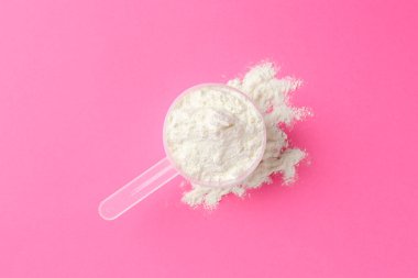 Protein tozu ve pembe arka planda kepçe, üst görünüm
