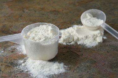 Gri desenli masadaki protein tozu ve kepçeler