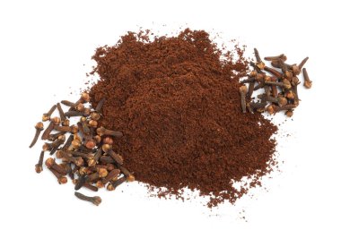 Beyaz arka planda karanfil tozu ve kurumuş tomurcuk yığını, üst manzara. Aromatik baharat
