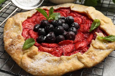 Gri masada böğürtlenli ve nane şekerli leziz galette, yakın plan.