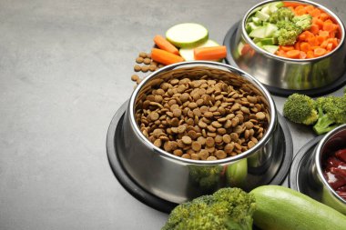 Gri masada kurutulmuş hayvan maması ve doğal ürünler, yakın plan. Metin için boşluk