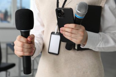 Mikrofonlu, akıllı telefonlu ve defterli bir gazeteci.
