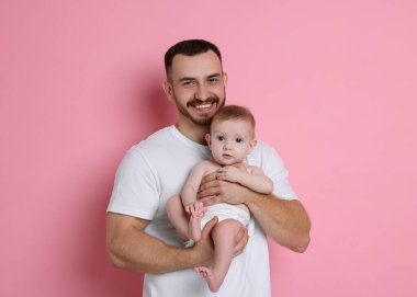 Pembe arka planda sevimli bebeği olan baba.