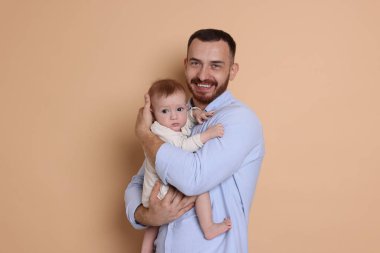 Bej arka planda sevimli bebeği olan baba.