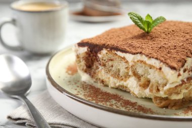 Beyaz masadaki lezzetli tiramisu parçası, yakın plan.
