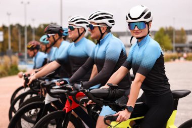 Dışarıda bisiklet süren bir grup atletik insan.