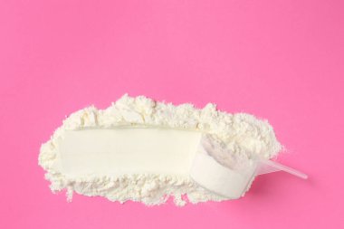 Protein tozu ve pembe arka planda kepçe, üst görünüm