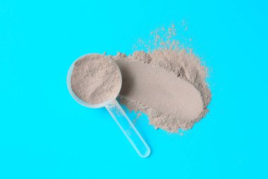 Protein tozu ve açık mavi arka planda kepçe, üst görünüm