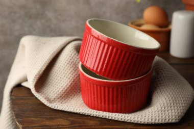 Red ceramic casseroles on wooden table, closeup clipart