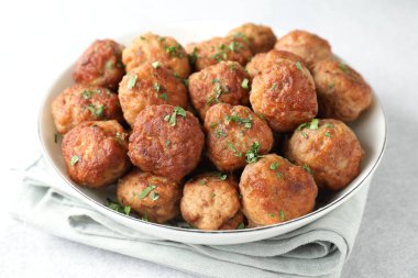 Lezzetli pişmiş köfteler ve yeşil soğan beyaz masada, yakın plan.