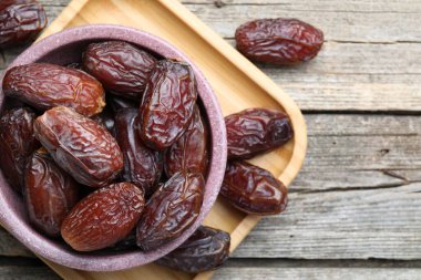 Tahta masadaki kasede bir sürü lezzetli kurutulmuş hurma var.