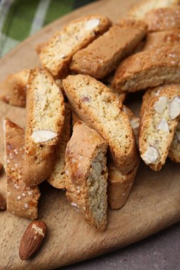 Lezzetli bademli bisküviler (Cantuccini) ve fındıklar kahverengi masanın üstünde, üst tarafta.
