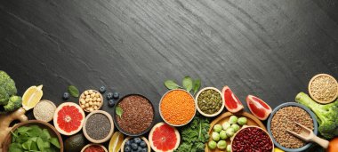 Different superfood products on black table, flat lay. Space for text