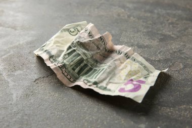Gri masaya buruşmuş bir dolar banknot, yakın plan.