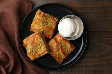 Ahşap masada ezilmiş fındıklı ve dondurmalı enfes baklavalar.