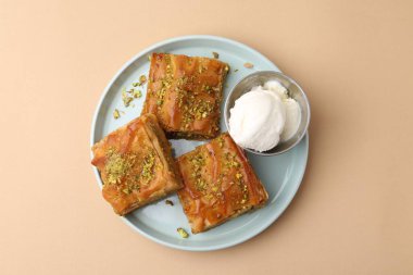 Lezzetli baklava ezilmiş fındık ve bej masa üzerinde dondurma, üst görünüm