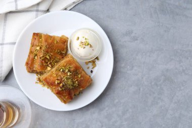 Lezzetli, fındıklı baklava ve gri masada bir kepçe dondurma. Metin için boşluk