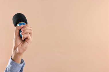 Bej arka planda mikrofonu olan adam, yakın plan. Metin için boşluk