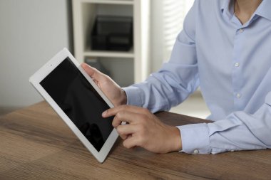 İşadamı ahşap masada tablet kullanıyor, yakın plan. Modern teknoloji