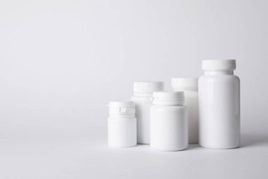 Beyaz arka planda birçok plastik tıbbi şişe, metin için boşluk