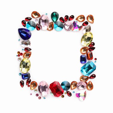 Beyaz arka planda, düz zeminde farklı parlak değerli taşların çerçevesi. Metin için boşluk