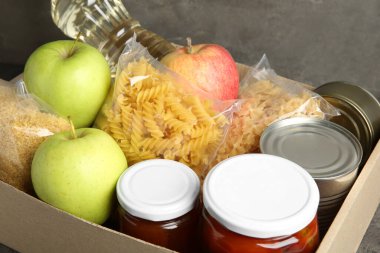 Masadaki kutuda bağış için farklı gıda ürünleri, yakın plan.