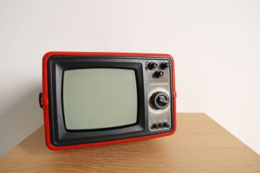 Beyaz duvara karşı komodinin üzerindeki Retro TV