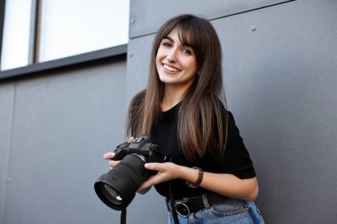 Binanın yakınında dijital kamerası olan profesyonel bir fotoğrafçı.