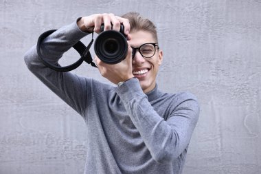 Profesyonel fotoğrafçı dışarıda kamerayla fotoğraf çekiyor.