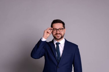 Gri arkaplanda gözlüklü bankacının portresi