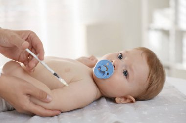 Pediyatrist klinikteki şirin bebeğe iğne yapıyor.