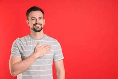 Man making promise on red background, space for text. Oath gesture clipart