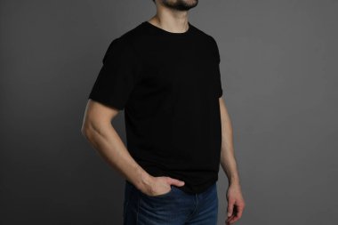 Gri arka planda siyah tişörtlü adam, yakın plan. Tasarım için model