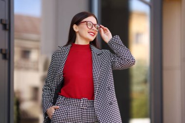 Havalı takım elbiseli, düşük açılı, gülümseyen iş kadını.