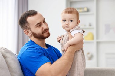 Baba ve küçük bebeği evdeki kanepede.
