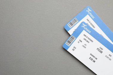 Seyahat acentesi. Gri arka planda uçuş biletleri, üst manzara. Metin için boşluk