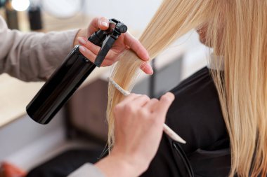 Saç kesimi. Profesyonel kuaför müşteriyle kuaförde çalışıyor.