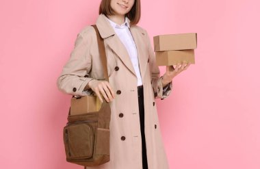 Happy postwoman with bag and parcels on pink background, closeup clipart