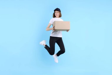 Happy postwoman with parcel jumping on light blue background clipart