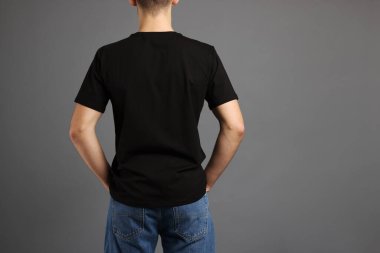Gri arka planda, şık tişörtlü bir adam. Tasarım için model