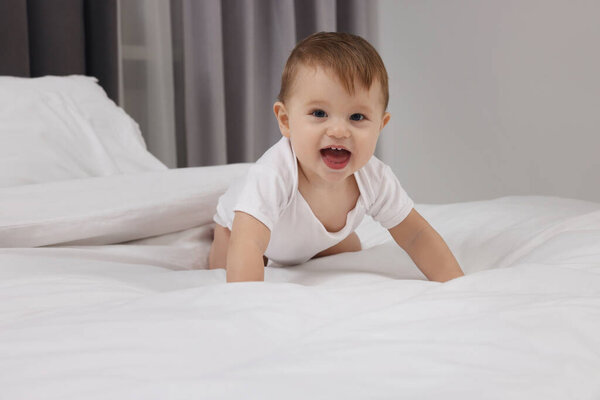 Funny little baby playing on bed at home