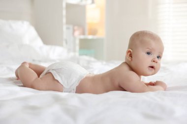 Yatakta bebek bezi içinde şirin bir bebek.