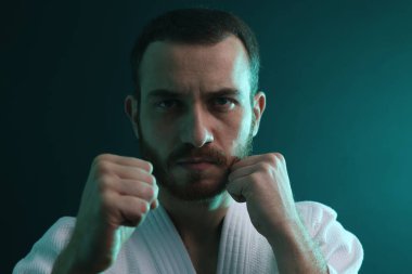 Karate dövüşçüsü renk ışıklarında üniforma giyiyor, yakın plan.