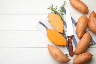 Taze çiğ patates, bıçak ve biberiye beyaz ahşap masada, düz yerde. Metin için boşluk