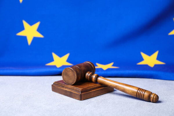 Judge's gavel and European Union flag on light grey table