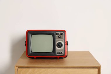 Beyaz duvara karşı komodinin üzerindeki Retro TV
