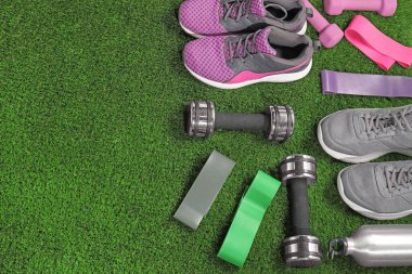 Suni çimlerin üzerinde farklı spor aletleri var. Metin için boşluk